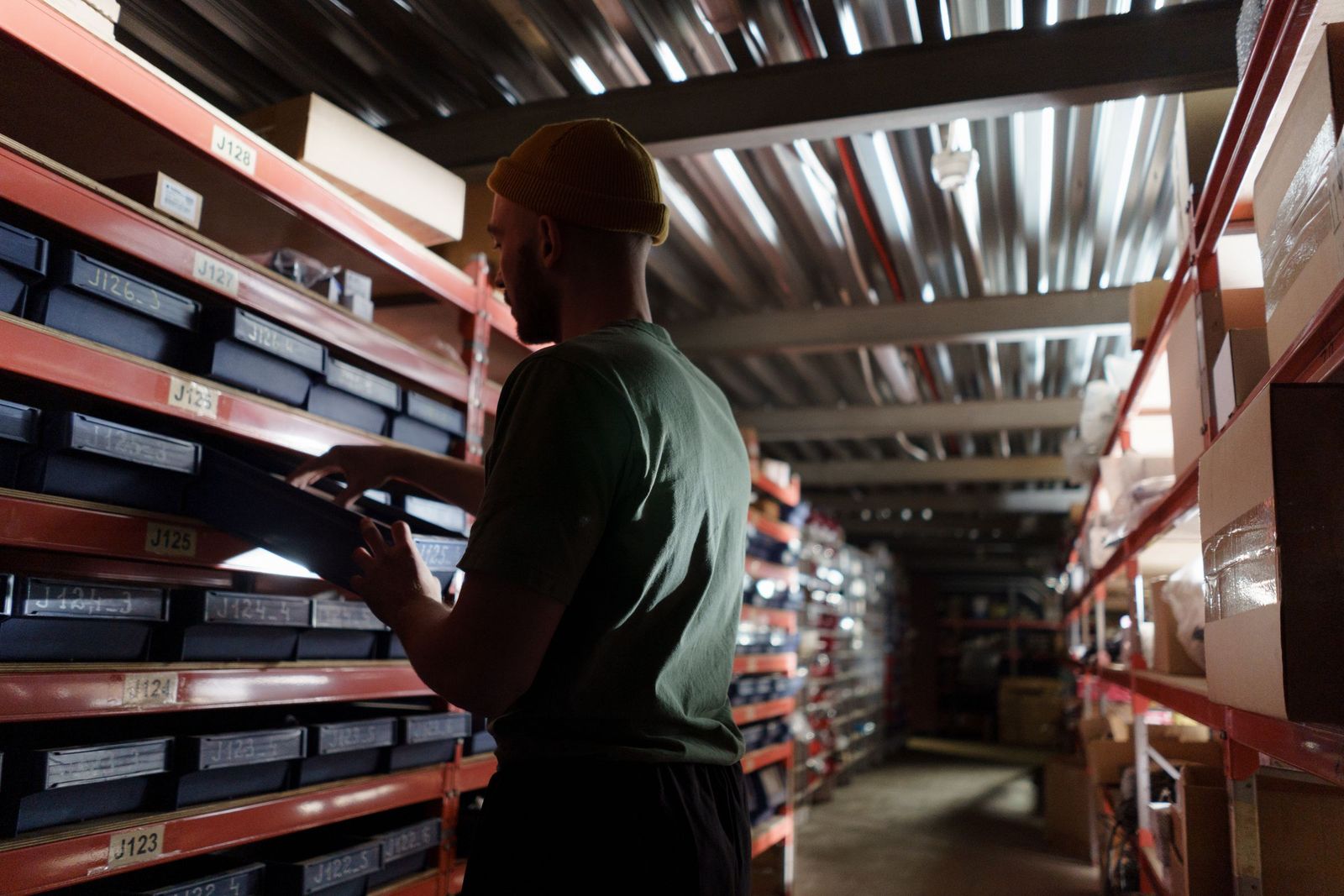 A man organising goods on warehouse shelves